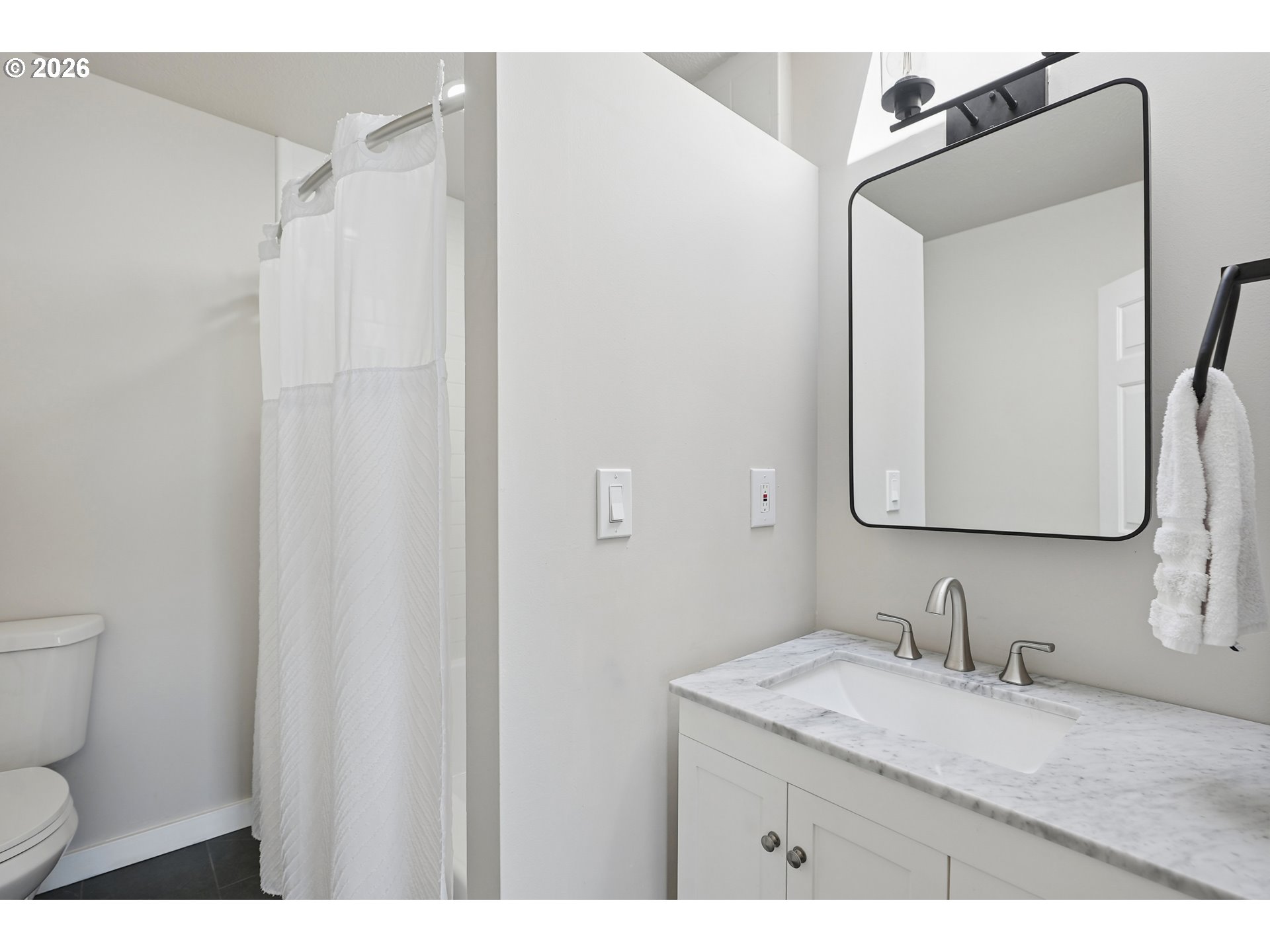 14936 Northwest Mill Road, Unit K Portland, OR 97231 - Photo 25 of 33 a bathroom with a granite countertop sink toilet and mirror