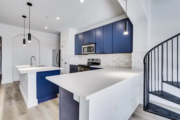 a kitchen with stainless steel appliances granite countertop a sink a stove a refrigerator and cabinets
