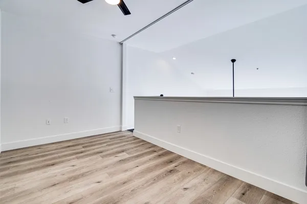 a view of a room with wooden floor and ceiling fan