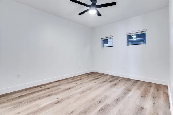 a view of a room with wooden floor and a ceiling fan