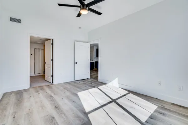 a view of a room with wooden floor and white walls
