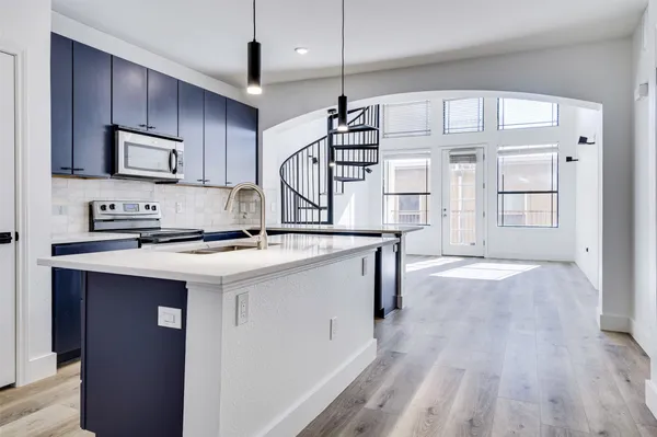 a kitchen with stainless steel appliances granite countertop a sink stove and wooden floor