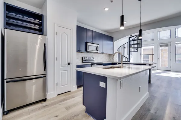 a kitchen with stainless steel appliances granite countertop a refrigerator a sink and a stove