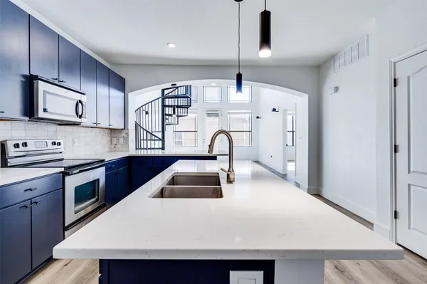 a kitchen with stainless steel appliances a stove a sink a microwave and cabinets