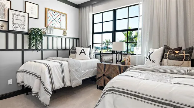 a bedroom with two beds and a large window