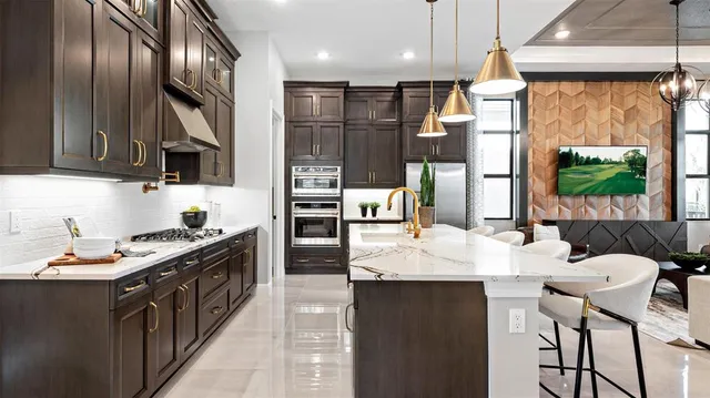 a kitchen with stainless steel appliances kitchen island granite countertop a stove a sink and a refrigerator