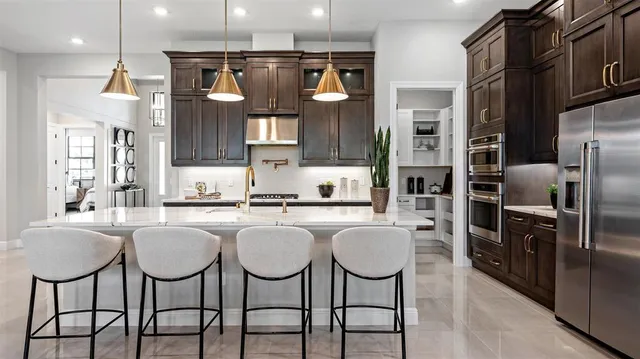 a kitchen with stainless steel appliances granite countertop a kitchen island a table and chairs