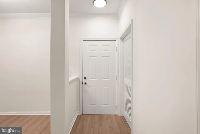 a view of an empty room with wooden floor and closet