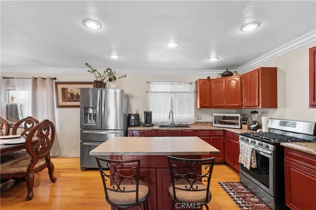 a kitchen with stainless steel appliances a table chairs and a refrigerator