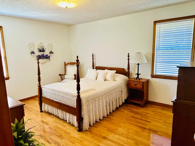 a bedroom with bed and wooden floor