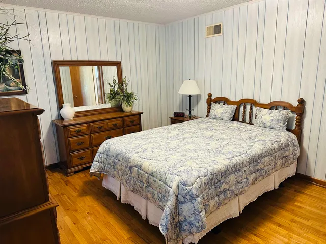 a bedroom with a bed lamp and a large window