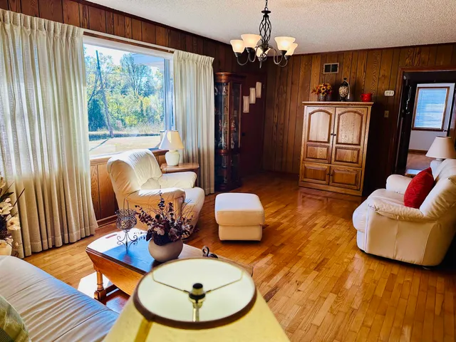 a living room with furniture chandelier and a large window
