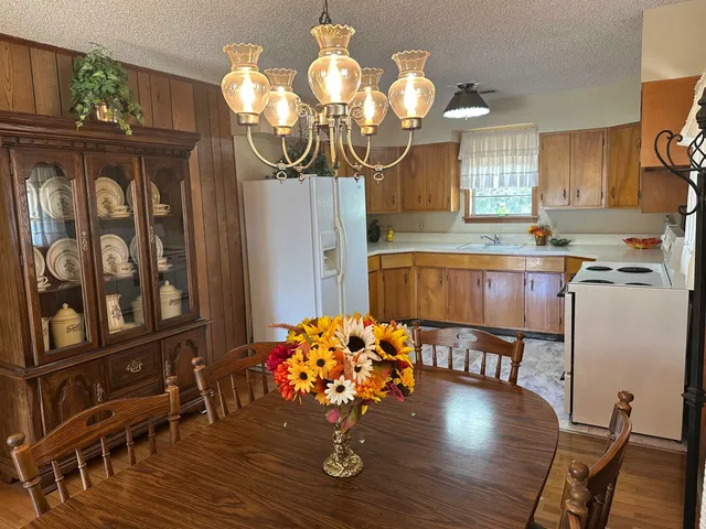 a dining room filled chandelier and wooden floor