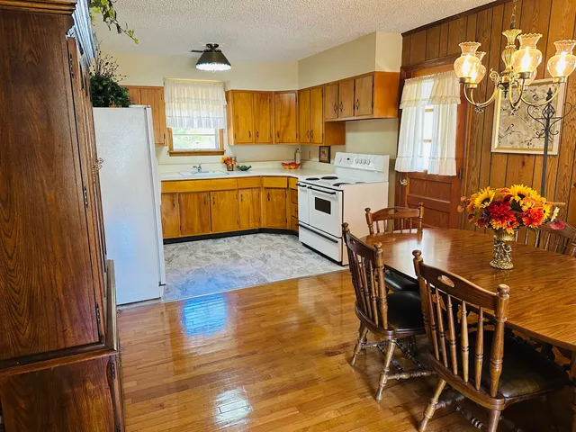 a kitchen with stainless steel appliances a stove a refrigerator a sink dishwasher with a dining table and chairs