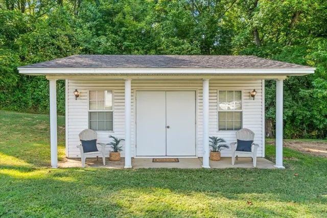 a view of a chair and table in the backyard with a garden