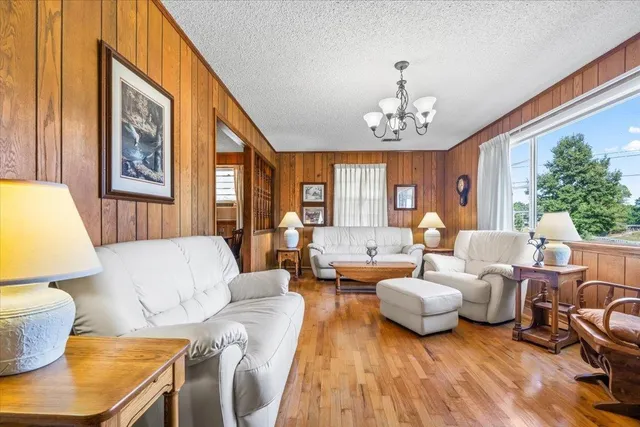 a living room with furniture chandelier and a large window