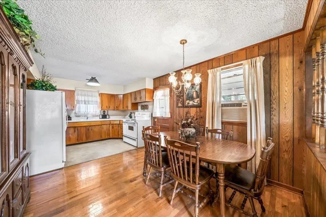 a kitchen with stainless steel appliances a dining table chairs and chandelier