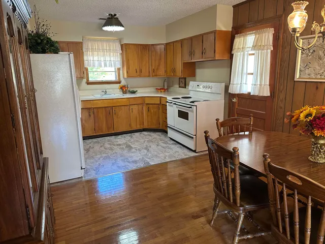 a kitchen with a table chairs refrigerator a sink a stove and cabinets