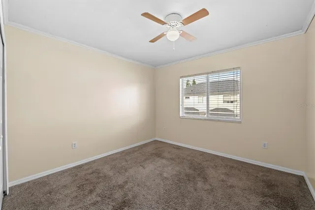 an empty room with a window and ceiling fan