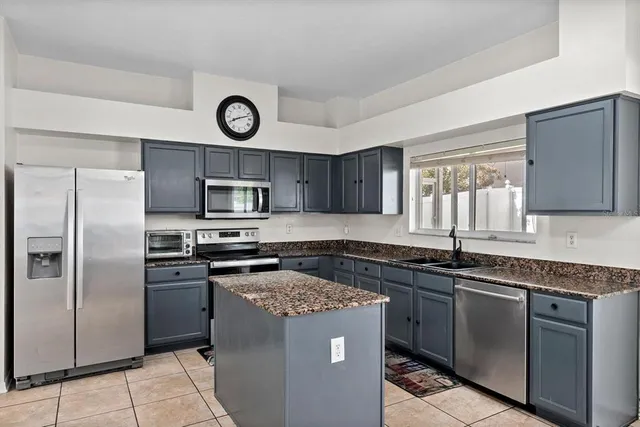 a kitchen with stainless steel appliances granite countertop a stove a sink and a refrigerator
