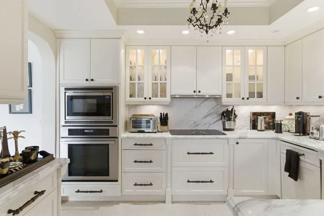 a kitchen with granite countertop white cabinets and stainless steel appliances