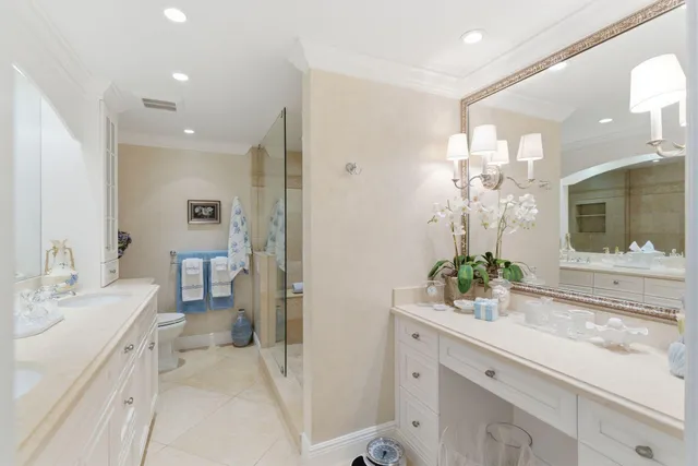 a spacious bathroom with a granite countertop sink a mirror and a toilet