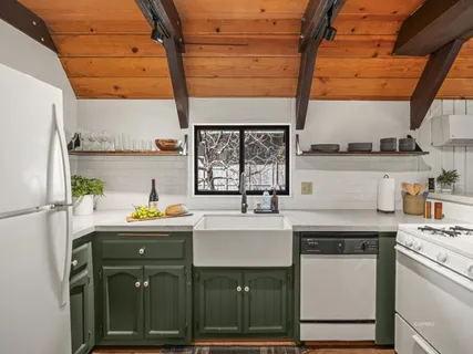 a kitchen with a sink a stove cabinets and a window