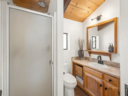 a bathroom with a granite countertop sink toilet and mirror