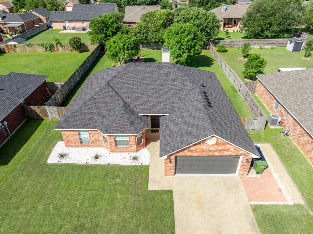 10512 Whitney Trace Drive Waco, TX 76708 - Photo 3 of 39 Brick exterior home featuring a dark shingle roof, attached garage, and a concrete driveway