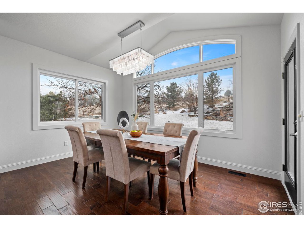 2097 Meander Road Windsor, CO 80550 - Photo 9 of 33 a view of a dining room with furniture a chandelier and wooden floor