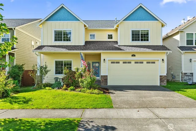 a front view of a house with a yard and trees