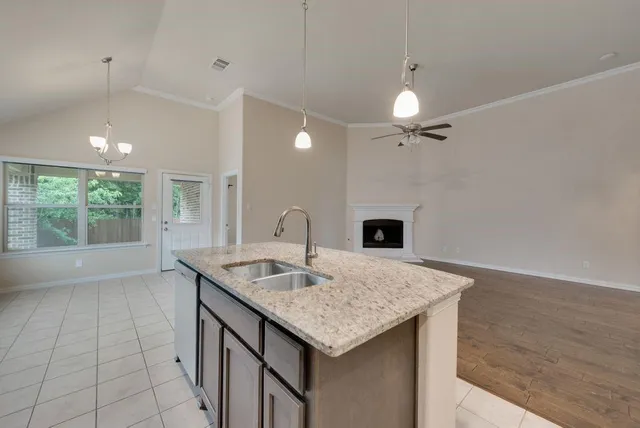a kitchen with a sink a counter space and a fireplace