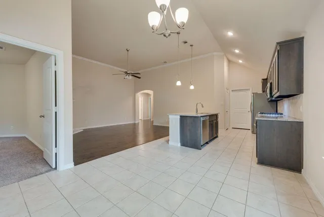 a kitchen with kitchen island a counter top space appliances and a ceiling fan