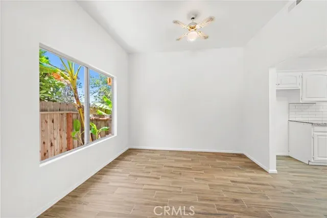 a view of an empty room with wooden floor and stairs