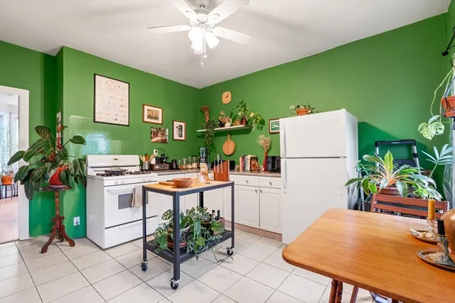 a kitchen with stainless steel appliances a table and chairs in it