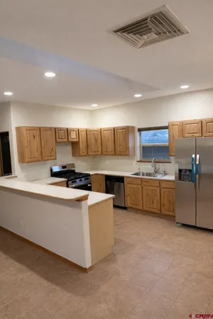 a large kitchen with a large counter top appliances and cabinets