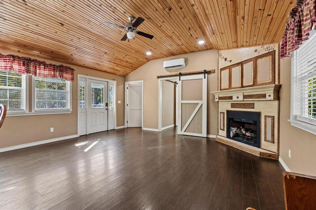 105 Reich Street Bonham, TX 75418 - Photo 6 of 31 a view of an empty room with wooden floor fireplace and a window