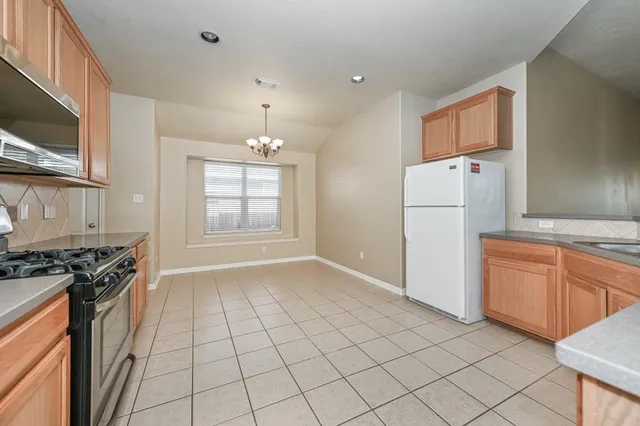 a kitchen with granite countertop cabinets stainless steel appliances and a window