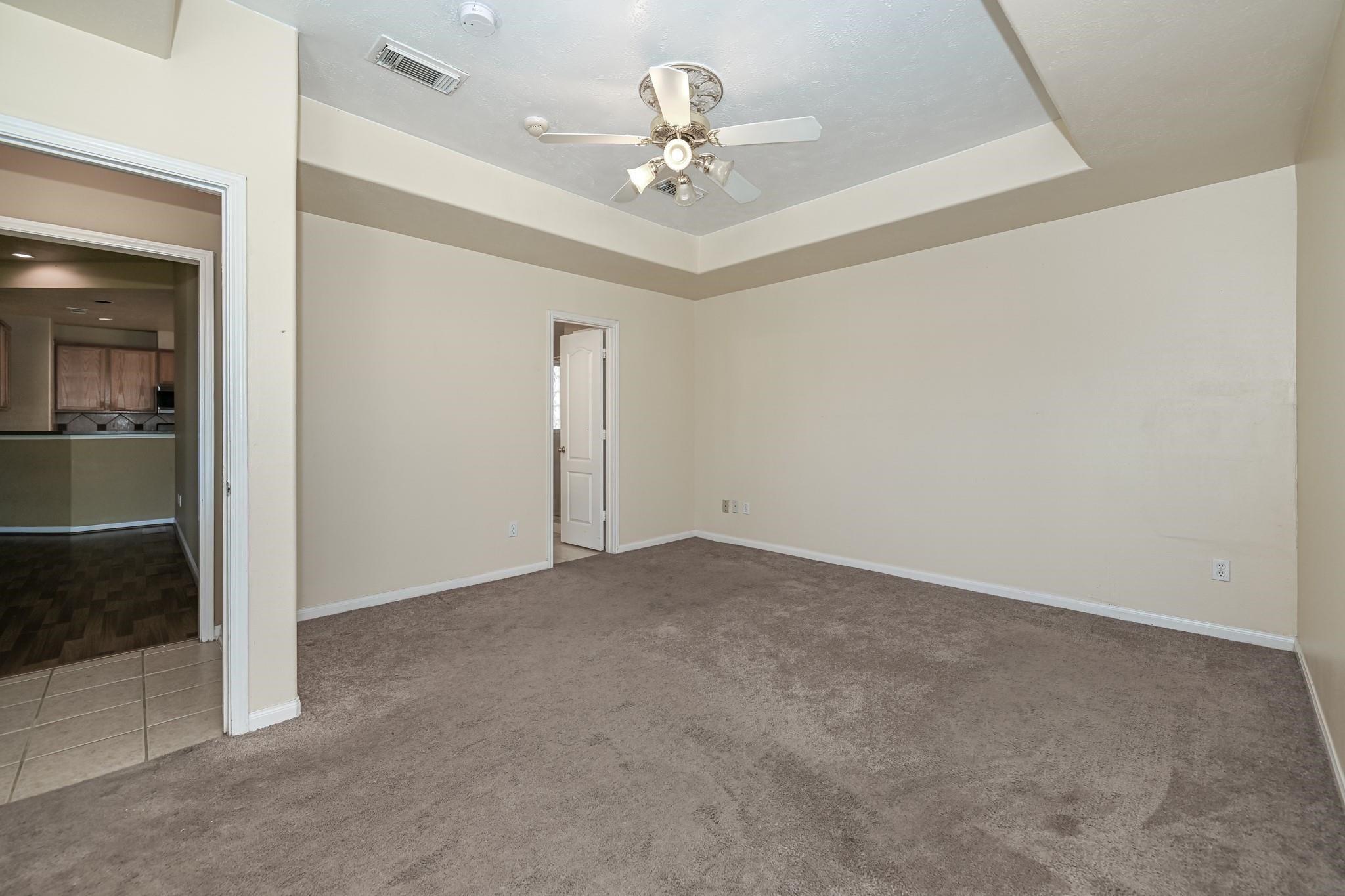 10002 Forest Spring Lane Pearland, TX 77584 - Photo 10 of 18 an empty room with a chandelier fan and windows