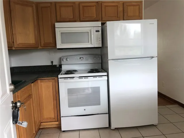 a kitchen with stainless steel appliances white cabinets and a refrigerator