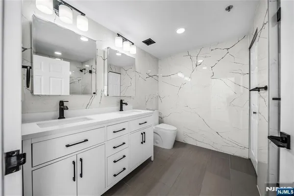 a bathroom with a double vanity sink toilet and shower