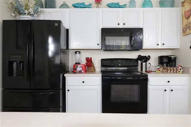 a kitchen with a refrigerator and cabinets