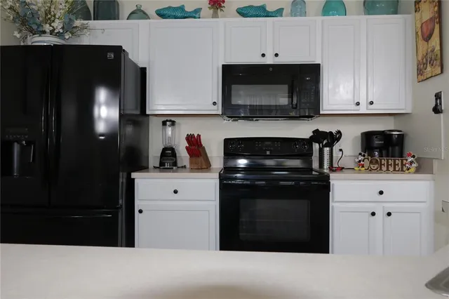 a kitchen with stainless steel appliances white cabinets and a refrigerator