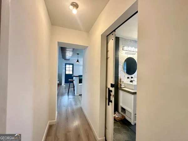a view of a hallway with wooden floor and living room