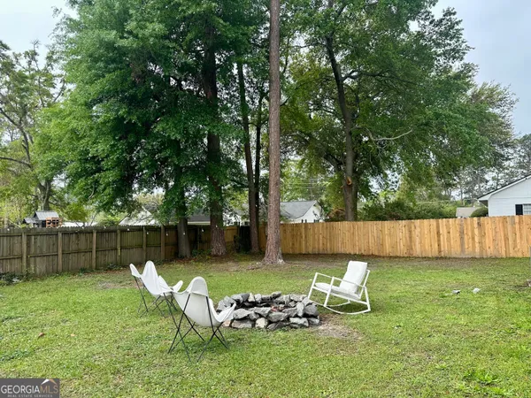 a view of a yard with a bench and trees