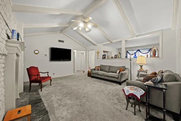 a living room with furniture a flat screen tv and kitchen view
