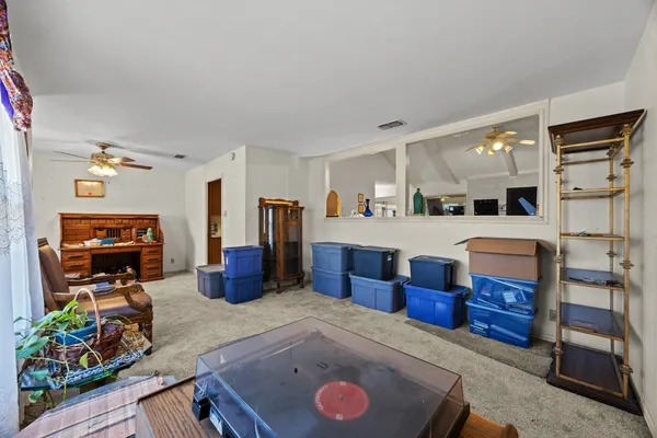 a living room with furniture a flat screen tv and a refrigerator