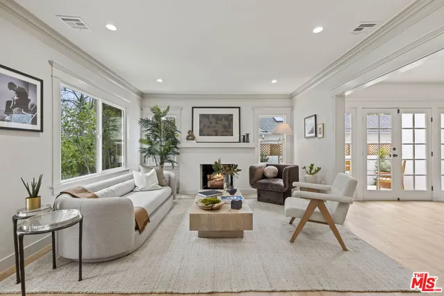 a living room with furniture fireplace and a large window