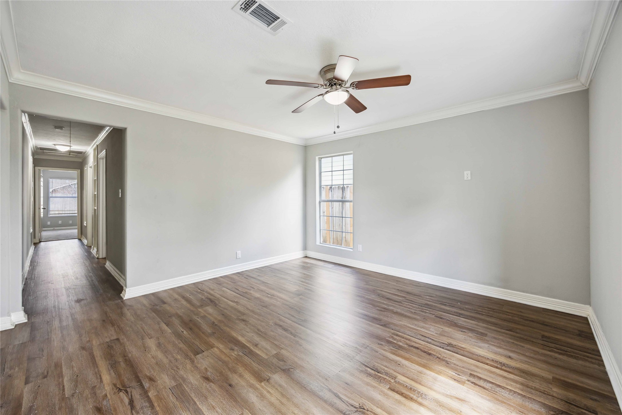 7150 Mobud Drive Houston, TX 77074 - Photo 10 of 29 a view of an empty room with wooden floor and a window