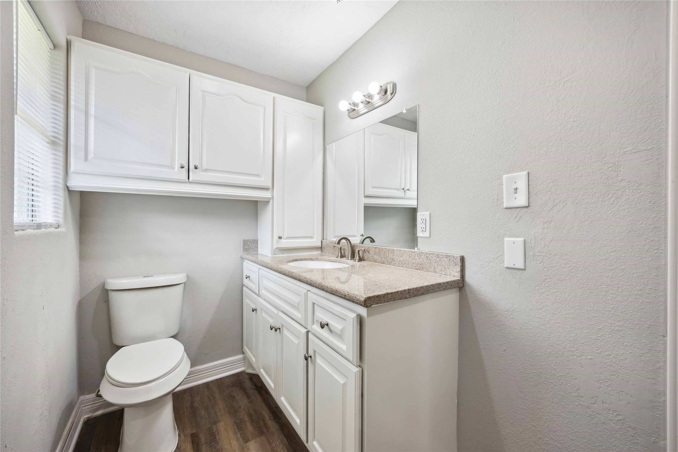 7150 Mobud Drive Houston, TX 77074 - Photo 21 of 29 a bathroom with a granite countertop toilet a sink and a mirror
